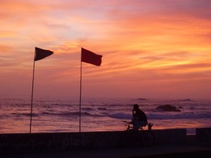Barranca at sunset. The left flag shows water quality is good, the right flag says no swimming due to turbulence.